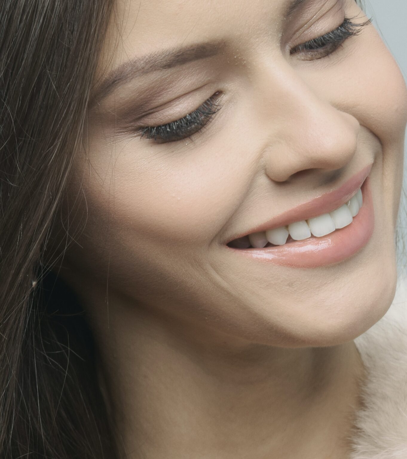 Close-up portrait of a smiling woman with brown hair at an affordable Dallas dentist clinic.
