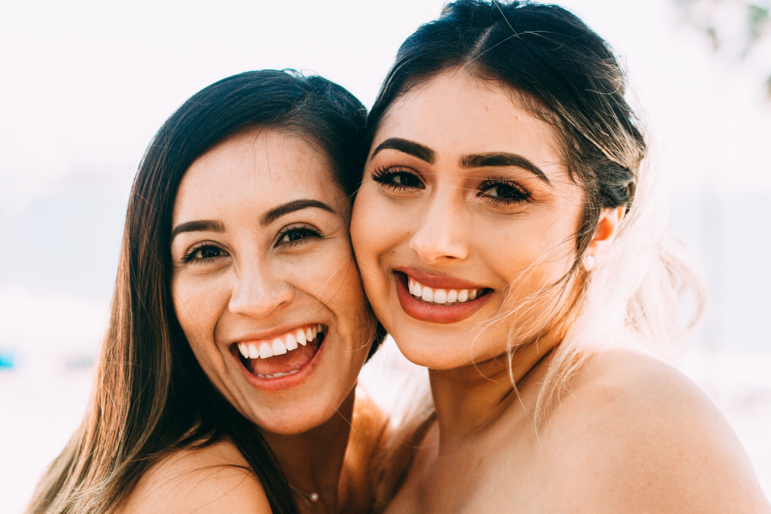 Two women smiling closely for a photo at a Dallas dental clinic.