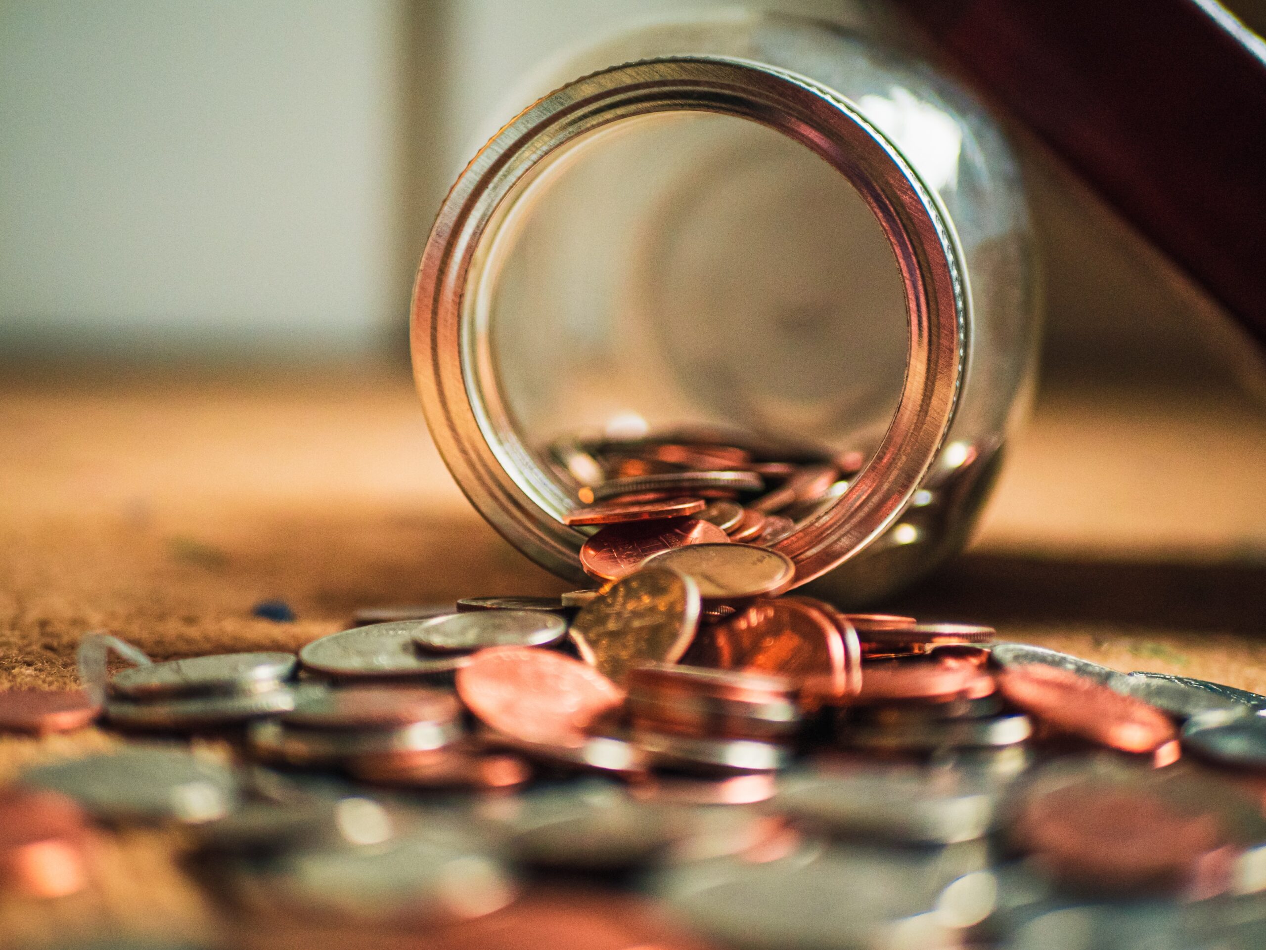 Coins spilling from an overturned jar onto the surface of a dental office.