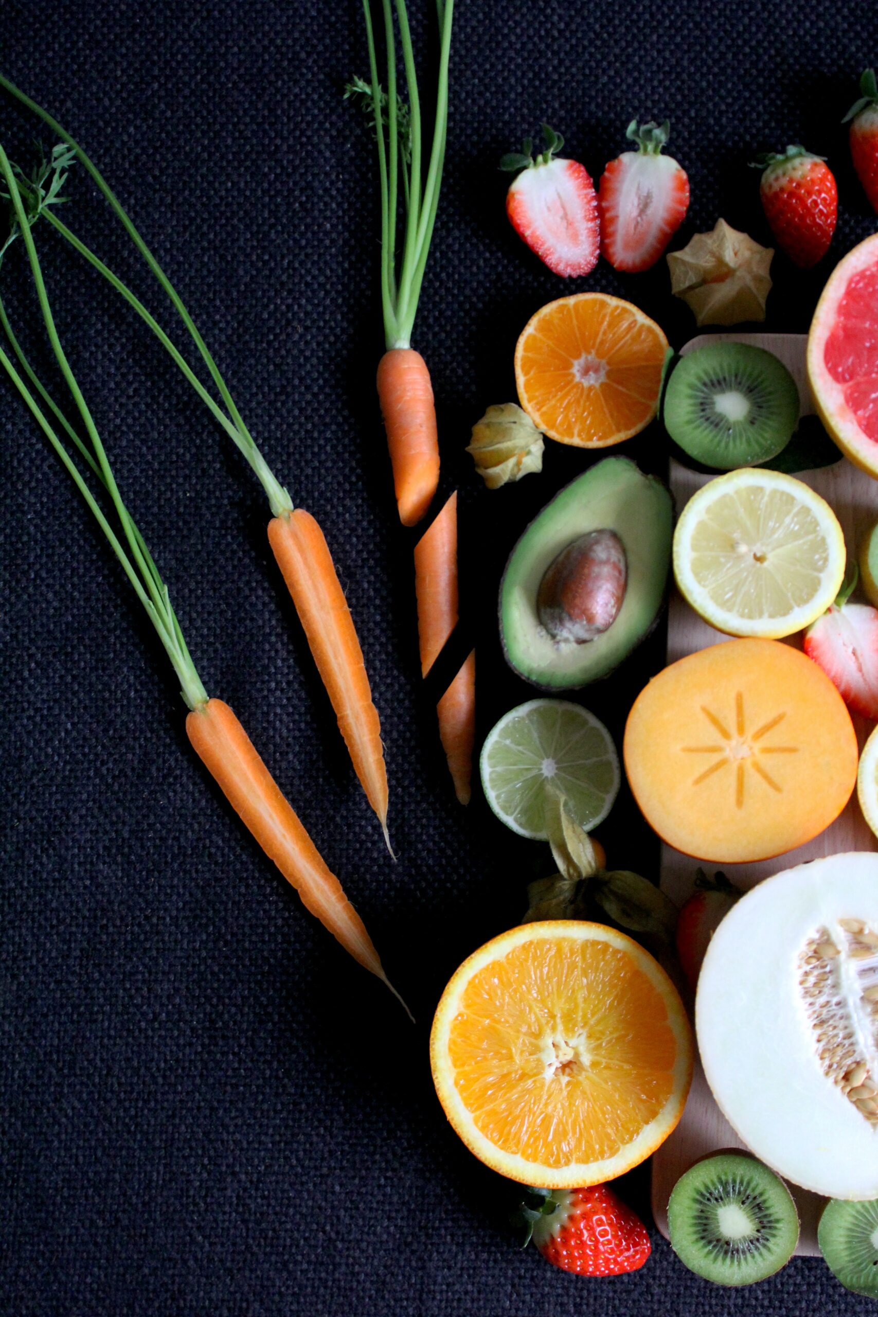 Assorted fresh fruits and vegetables neatly arranged on a dark background at a Texas dental office.