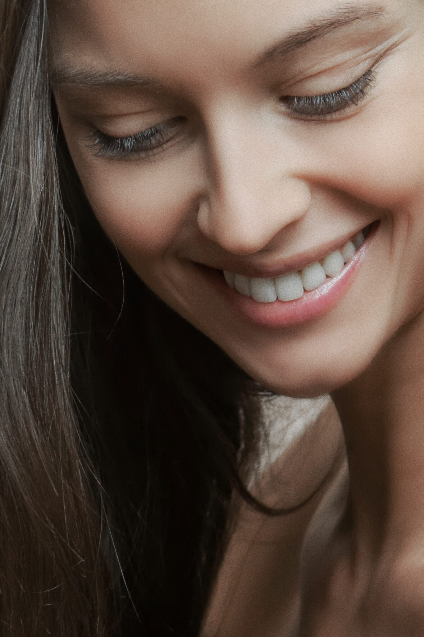 A close-up of a smiling woman with closed eyes at the dentist.